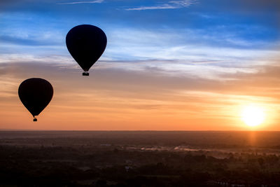 Hot air balloon flying against sky during sunset