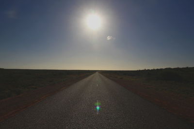 Road amidst green landscape against sky