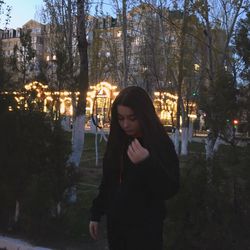 Woman standing in city at night during winter