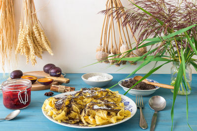 Low angle view of sweet pasta dessert, noodles with poppy seeds on white background table.