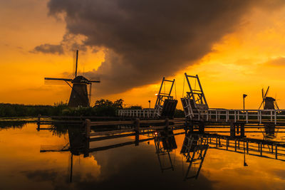 Cranes against sky during sunset