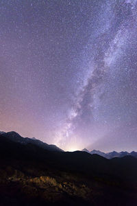 Scenic view of mountains against sky at night