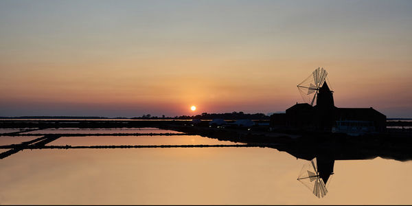 Silhouette built structure against sky during sunset
