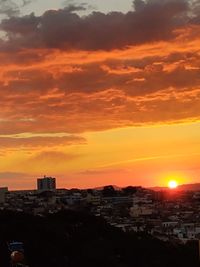 Silhouette buildings against sky during sunset