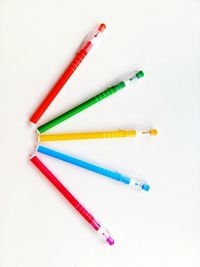 High angle view of colored pencils against white background