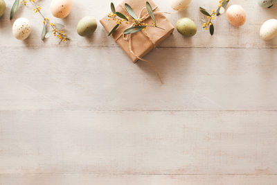 Easter background - easter eggs and eucalyptus leaves garland on wooden background with copy space