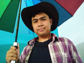 Portrait of young man holding hat