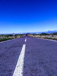 Surface level of road against blue sky