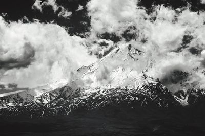 Scenic view of snowcapped mountains against cloudy sky