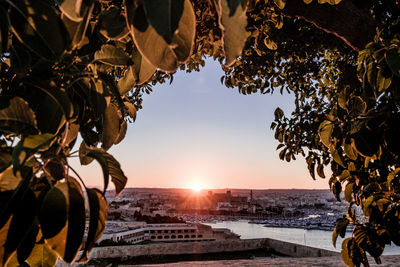 Scenic view of sea and harbour against sky during sunset