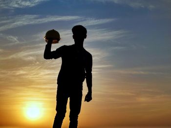 Silhouette men standing against sky during sunset