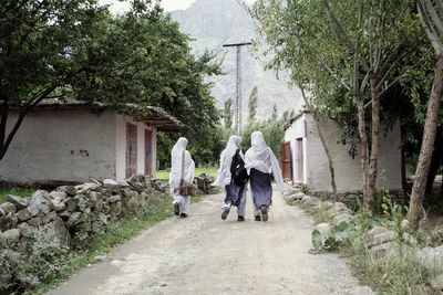 Rear view of people walking on footpath