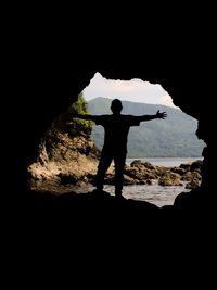 Silhouette of people standing in cave