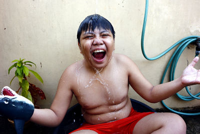 Happy boy sitting on wet floor