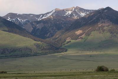 Scenic view of field and mountains against sky