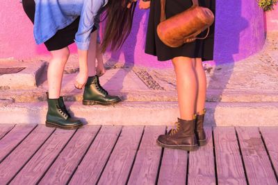 Low section of woman standing on wooden floor