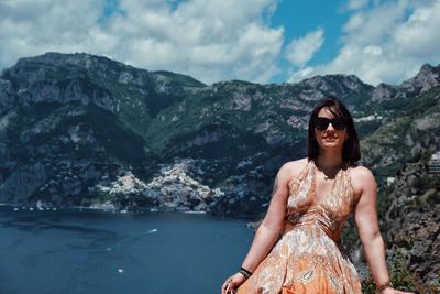 Smiling young woman in mountains against sky