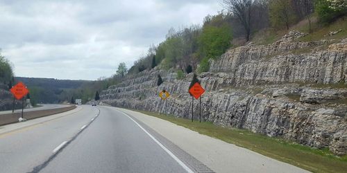 Road passing through mountains against cloudy sky