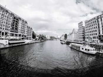 Buildings in city against cloudy sky