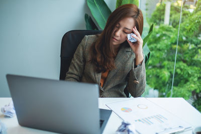 Young businesswoman using laptop at office