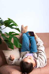 Young woman at home on the couch with a phone in her hand. the concept of remote work.
