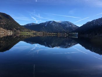 Scenic view of lake and mountains against blue sky