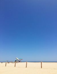 Scenic view of beach against clear blue sky