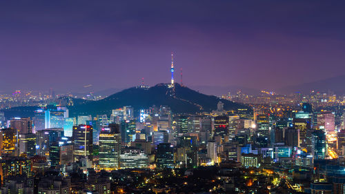 Illuminated cityscape against sky at night