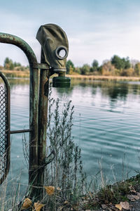 Close-up of wooden post in lake against sky