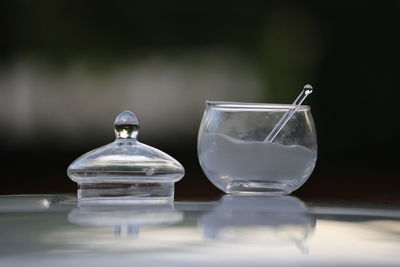 Close-up of sugar in glass container on table