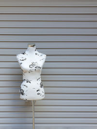 Mannequin stand against corrugated metal wall