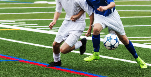 Low section of people relaxing on soccer field