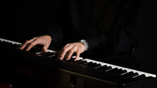 Cropped hands playing piano