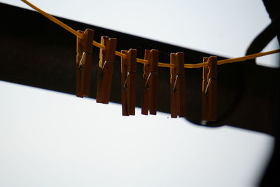 Close-up of clothespins hanging on railing