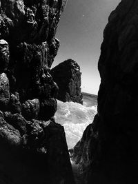 Rock formations by sea against sky