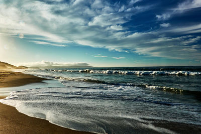 Scenic view of beach against sky during sunrise