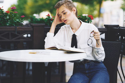 Young woman sitting on table at restaurant