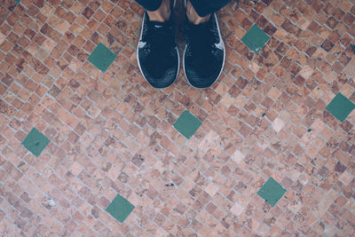 Low section of woman standing on tiled floor