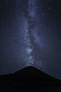 Silhouette mountain against star field