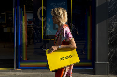 Rear view of woman standing at store