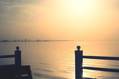Pier on sea at sunset