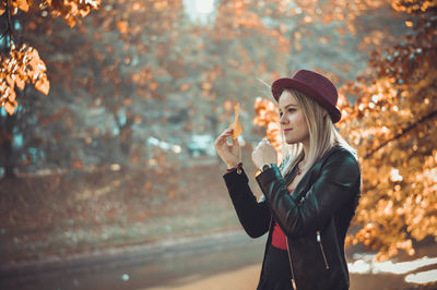 Smiling beautiful woman holding leaf