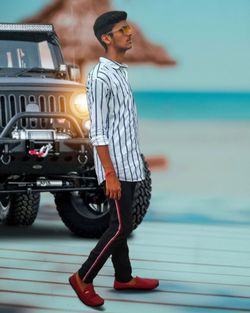 Full length of young man standing on car