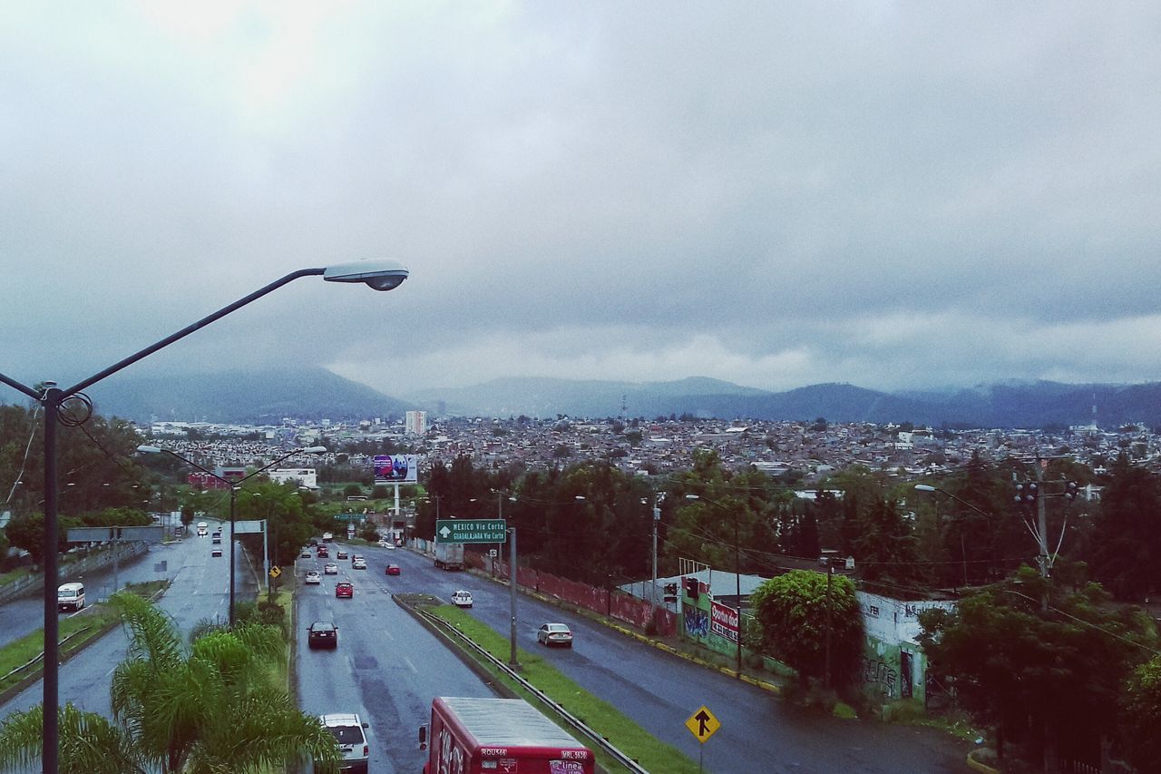 AERIAL VIEW OF CITY AGAINST CLOUDY SKY