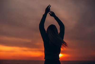 Silhouette woman standing against sky during sunset