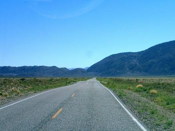 Empty road leading towards mountains