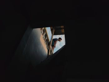 Low angle view of silhouette woman standing by staircase