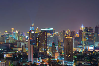 Illuminated buildings in city against sky at night