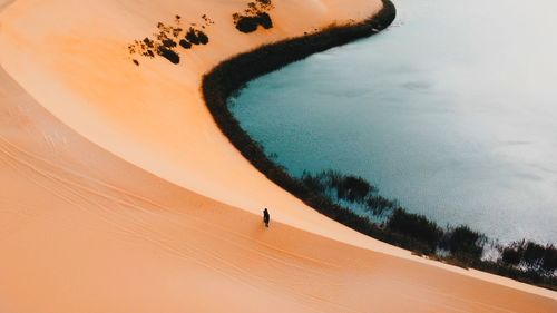 Drone view of sand dune against lake