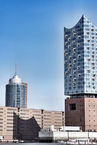 Low angle view of office buildings against blue sky